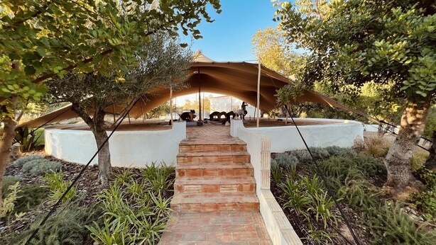 A pathway leading to a covered seating area with a white wall and a brick border. - SOLAR ALVURA HEALTH HOTEL (Olhao)