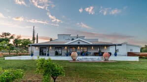 A modern house with a covered patio, large potted plants, and a well-maintained lawn. - SOLAR ALVURA HEALTH HOTEL (Olhao)