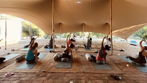 A group of people performing yoga under a canopy in an outdoor setting. - SOLAR ALVURA HEALTH HOTEL (Olhao)