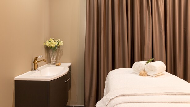 A bathroom with a sink, mirror, and a vase of flowers. - SOLAR ALVURA HEALTH HOTEL (Olhao)