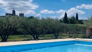 Una piscina con cielo azzurro e alberi sullo sfondo.