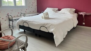 Una camera da letto con un letto, una sedia, un comodino e una finestra.