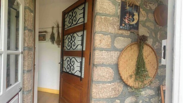 A stone wall with a wooden door featuring decorative metal panels. - Maison MaxAnne, half village, half authentic countryside (Corrèze)