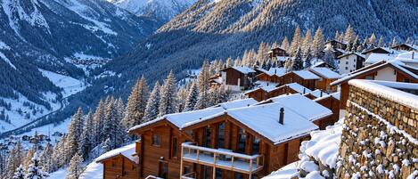 A snow-covered mountain village with wooden buildings and a clear sky.