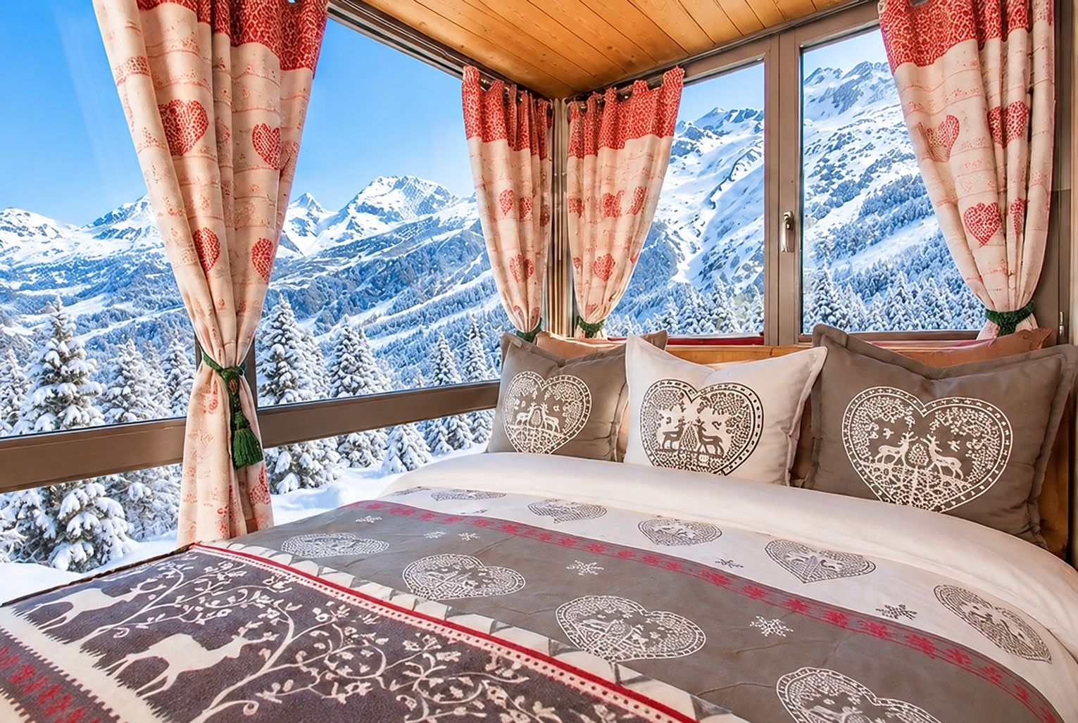 A bedroom with a large bed, heart-patterned curtains, and a view of snow-covered mountains.