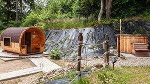 Une cabane en bois avec un toit en pente, une petite véranda et une terrasse en bois.