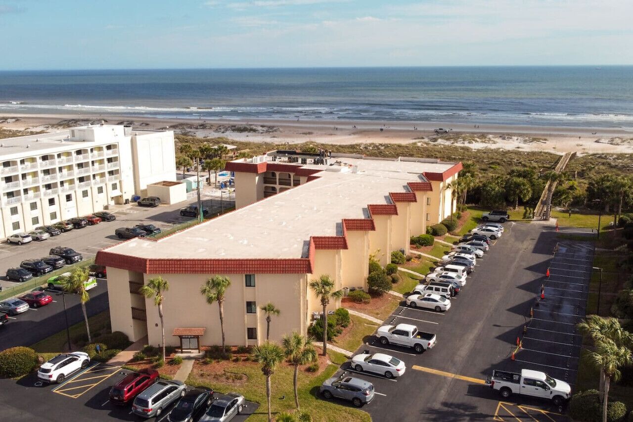 Ein Hotel mit Parkplatz und Blick auf den Strand.