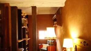 Un coin lecture confortable avec un fauteuil, des étagères et une lampe.