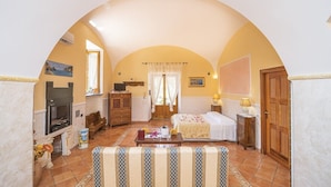 Una stanza accogliente con camino, un letto, una poltrona e un tavolo da pranzo.