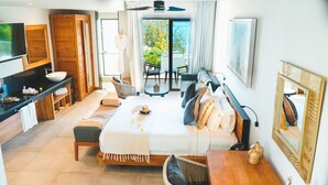 A modern hotel room with a large bed, a TV, a bathroom with a sink, and a view of the outdoors. - Wonders Beach Boutique Hotel (Mont Choisy)