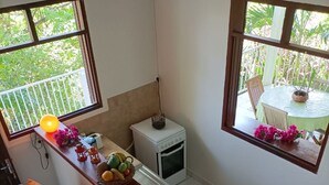 A kitchen with a central island, a small oven, and a dining area with chairs and a table.