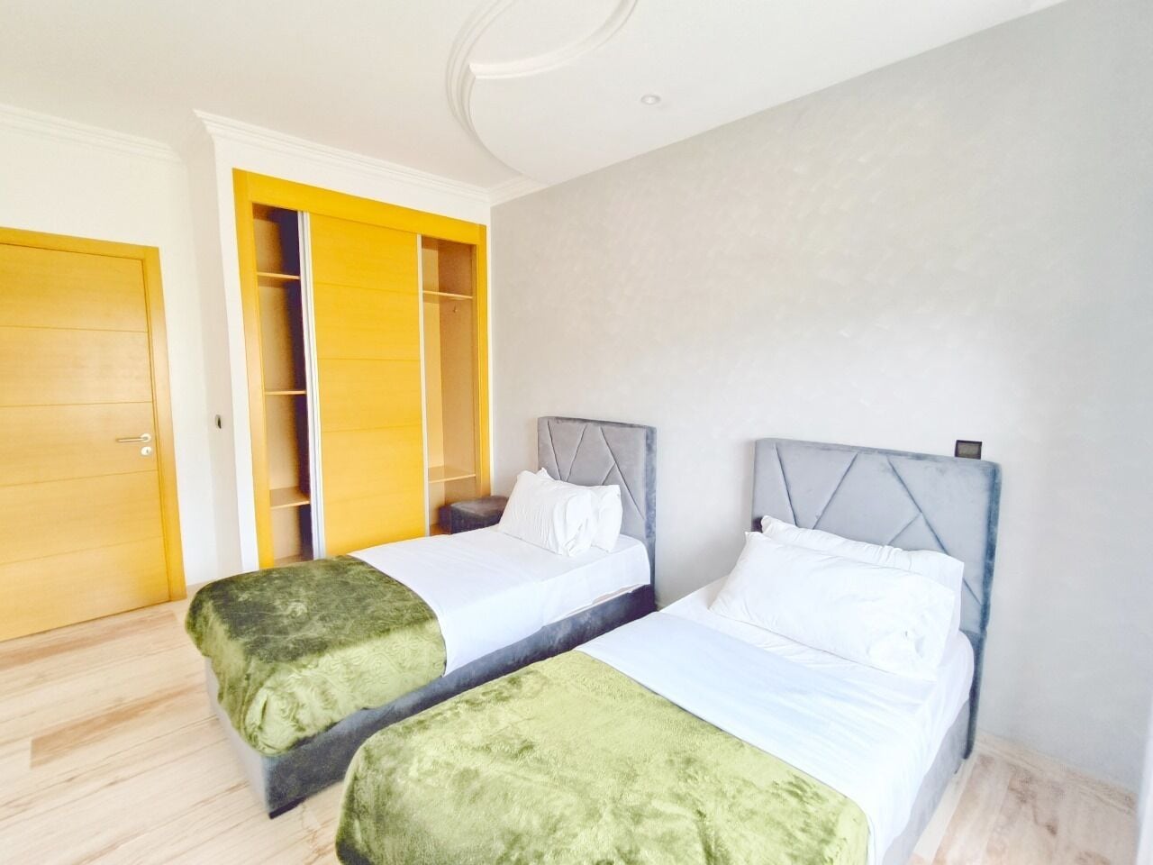 A hotel room with two beds, a wardrobe, and a closet.