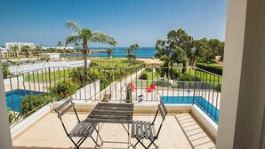 A balcony with a view of the sea, a pool, and a garden. - Villa Mesogeios Me16 (Paralimni)