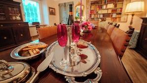 Une table à manger avec une bouteille, deux verres et un plateau de collations.