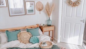 Ein ordentlich eingerichtetes Schlafzimmer mit Bett, Nachttisch und Tür.