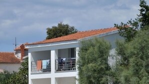 A two-story building with a balcony, situated by a body of water. - Seafront Ground Floor (Zadar)