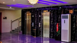 A modern lobby with marble flooring, a staircase, and elevators. - Ughelli Wetland Hotel (Ughelli)