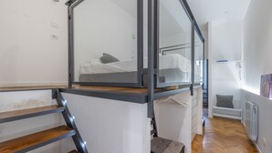 Ein modernes Schlafzimmer mit Etagenbett, einer Holztreppe und Blick auf den Flur.