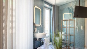 A modern bathroom with a large mirror, a sink, and a shower area. - Feel Porto Sublime Townhouse (Oporto)