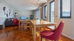 A modern dining area with a wooden table, red chairs, and a laptop on the table. - Feel Porto Sublime Townhouse (Oporto)