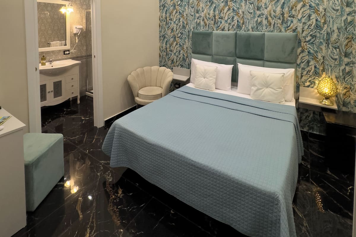 Un dormitorio moderno con una cama grande, un tocador con espejo y una silla.