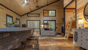 A cozy cabin interior with a wooden interior, a fireplace, a sofa, and a dining area. - Ride to ATV Trails + Dog Run + Game Room + Bunk Bed Nook + Guests Favorite (Broken Bow)