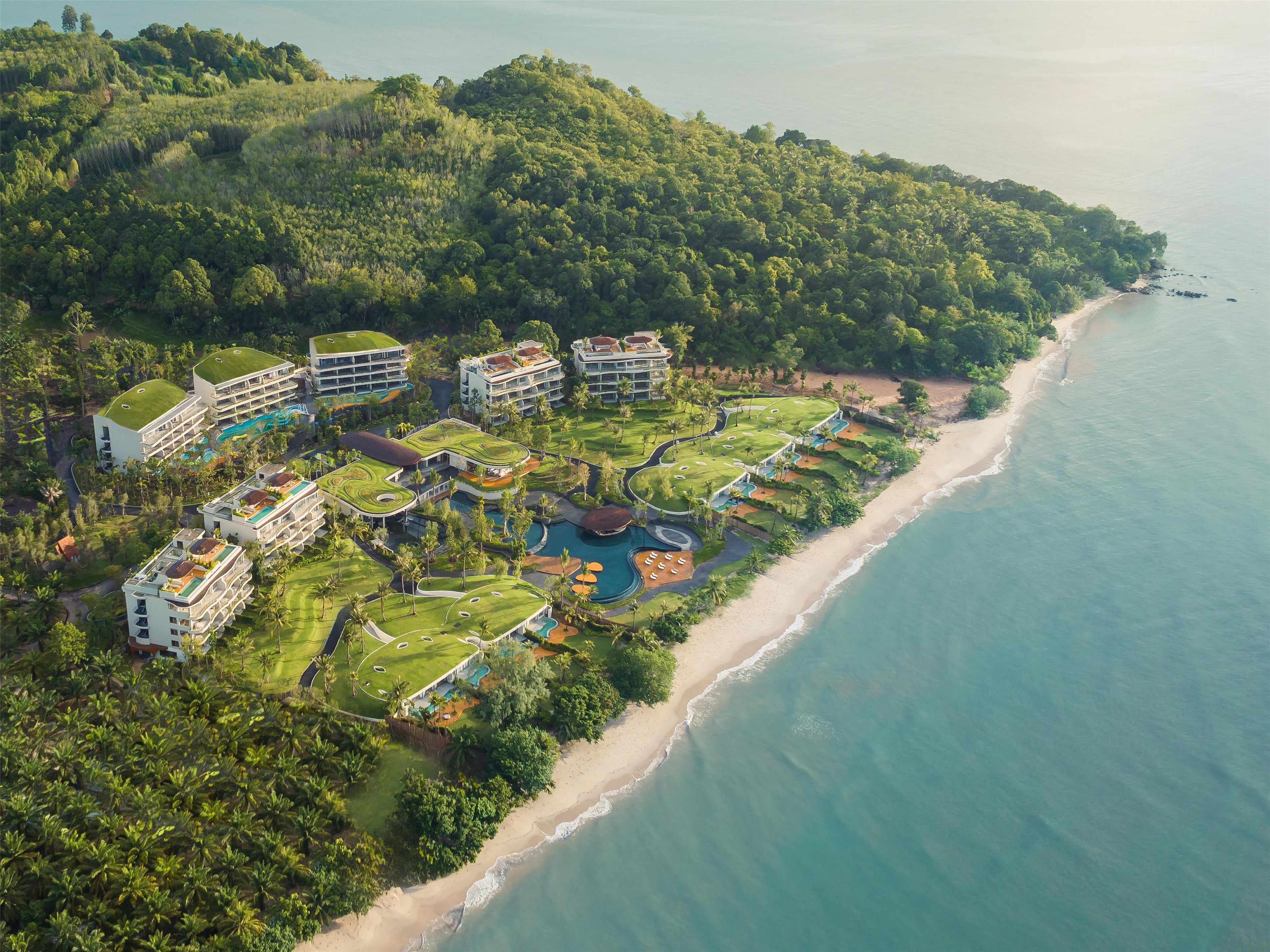 A resort with multiple buildings, a golf course, and a beach.