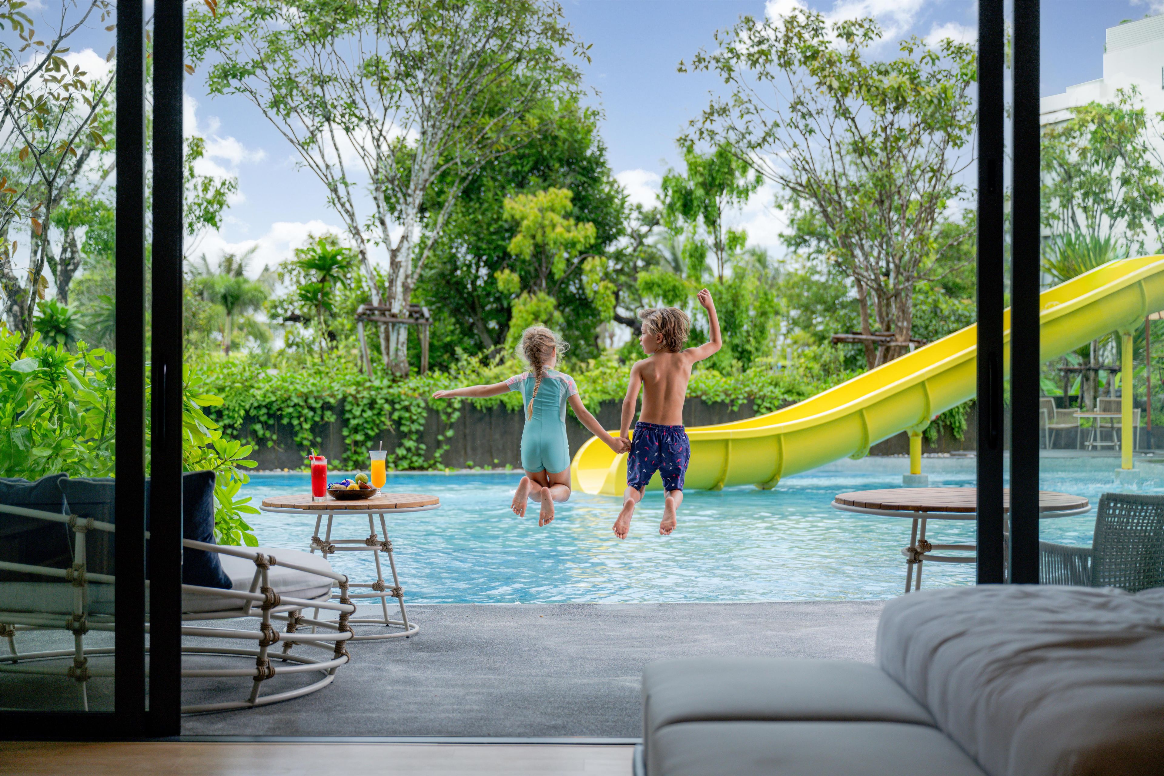 Ein Poolbereich mit Rutsche, Liegestühlen und einem Tisch mit Getränken.