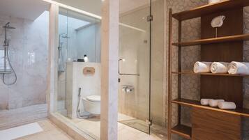 Une salle de bain moderne avec une douche à parois de verre, un meuble-lavabo en bois agrémenté de serviettes et un revêtement de sol en marbre.