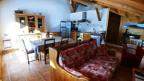 A cozy, rustic kitchen with wooden cabinets, a dining table, and a sofa. - Les Salamanes - 3 double bedrooms - 2 bathrooms - domaine du Grand Massif (Sixt-Fer-à-Cheval)