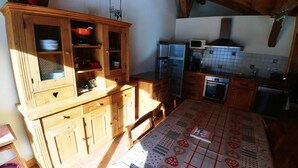 A compact kitchen with wooden cabinets, a microwave, and a stove. - Les Salamanes - 3 double bedrooms - 2 bathrooms - domaine du Grand Massif (Sixt-Fer-à-Cheval)