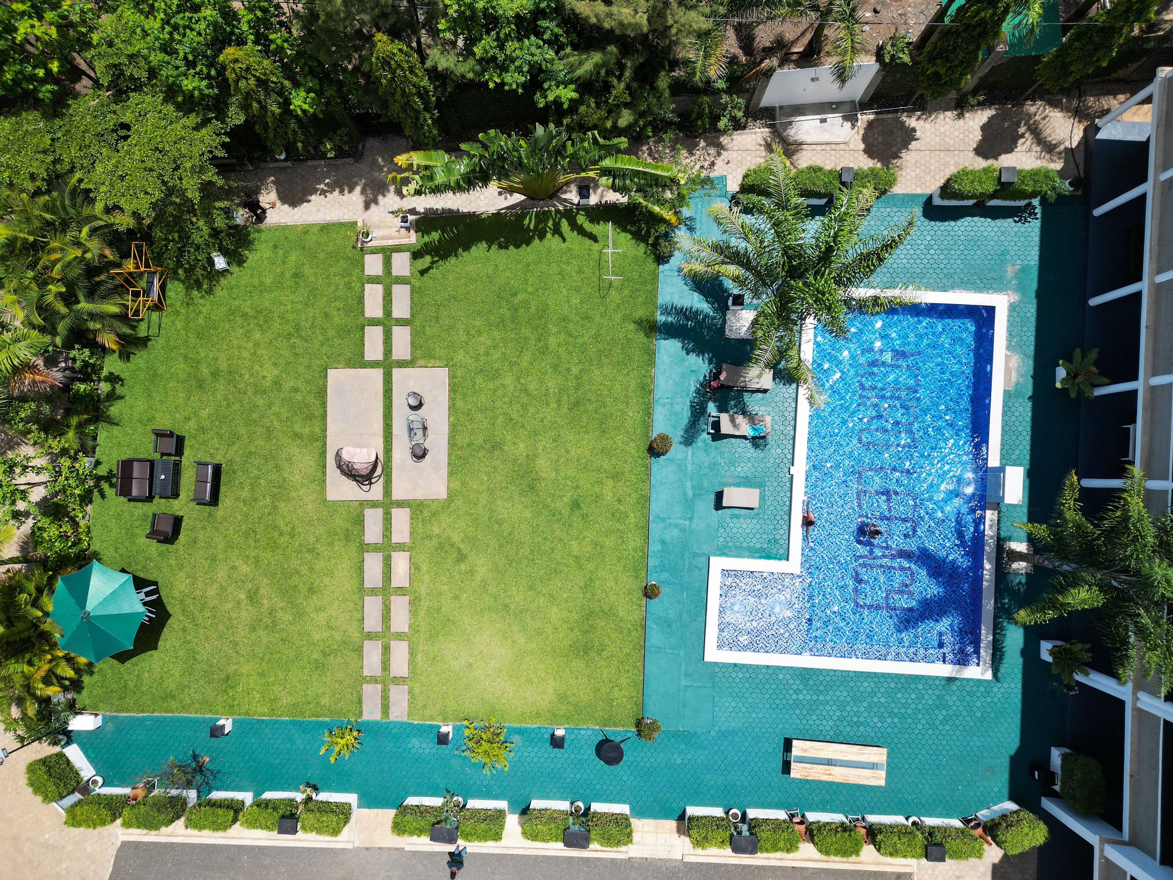 Vue aérienne d’un hôtel doté d’une piscine, d’un espace extérieur aménagé et d’une pelouse bien entretenue.