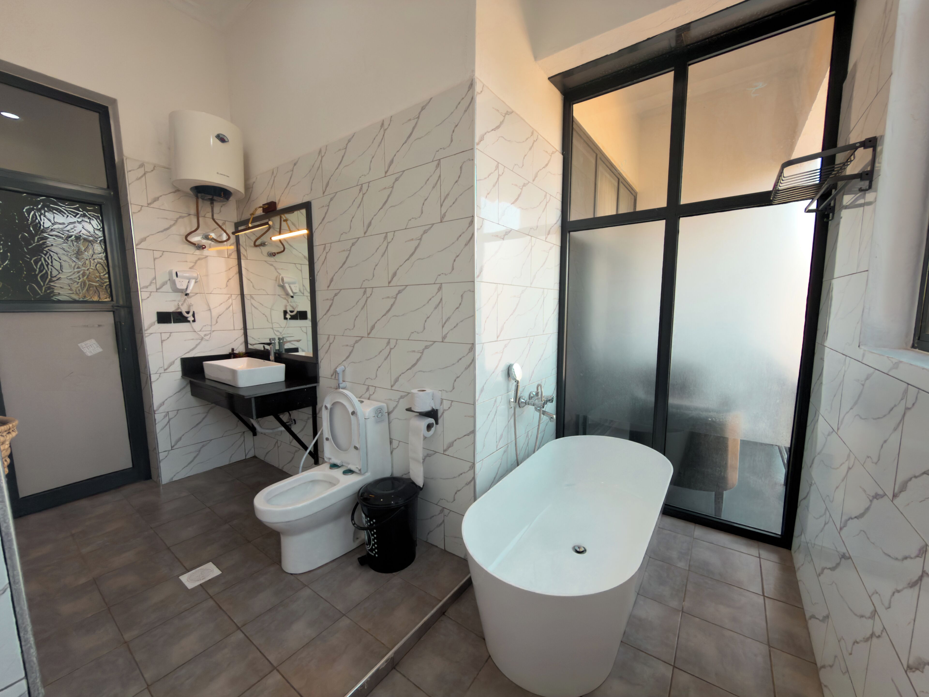A modern bathroom with a toilet, bidet, and bathtub.