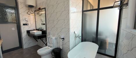 A modern bathroom with a toilet, bidet, and bathtub.