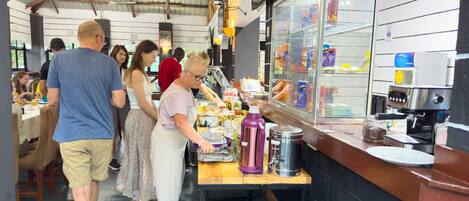 Una cafetería con mostrador, máquina de café y diferentes productos alimenticios.