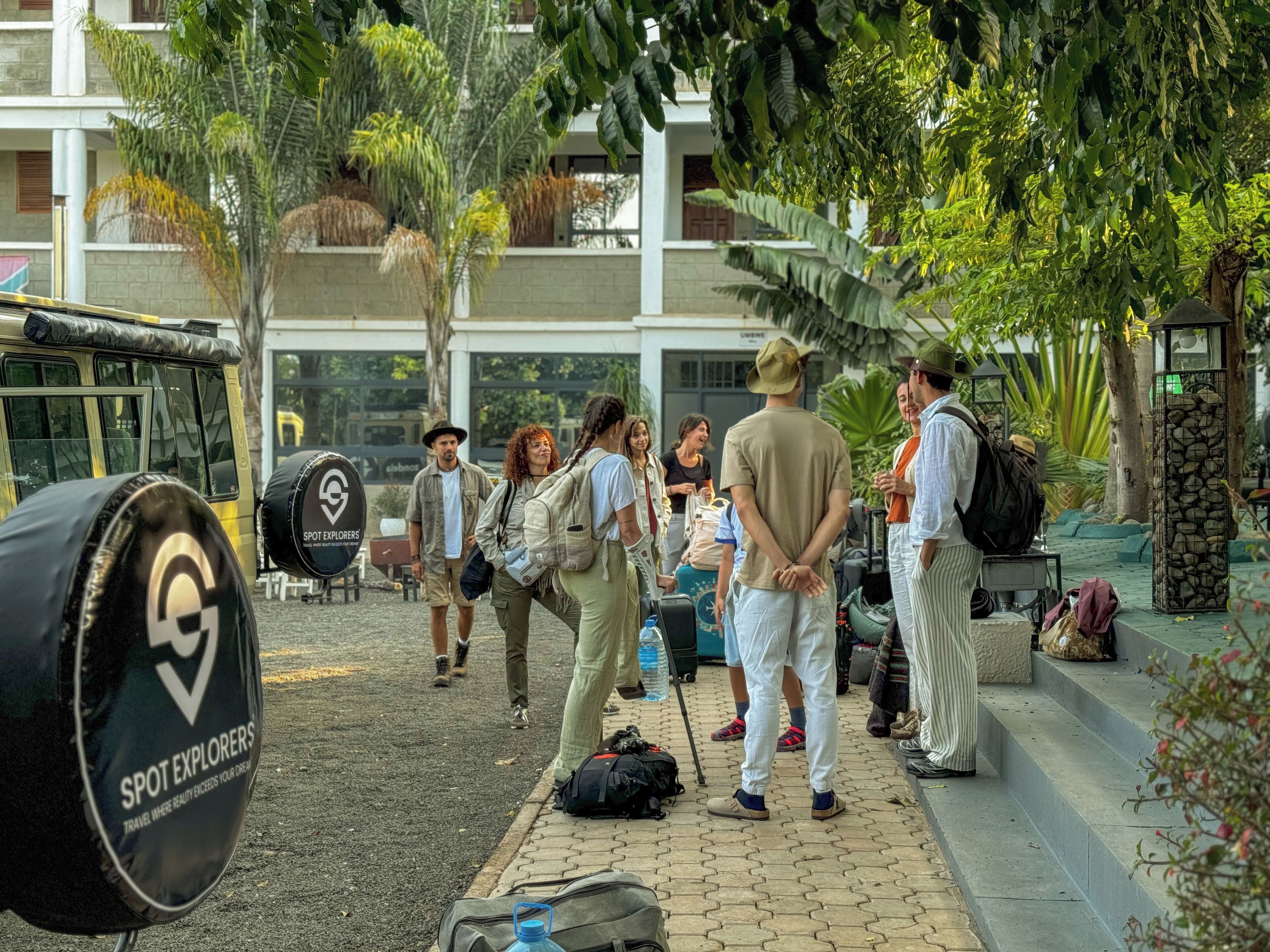A group of people standing near a bus with a sign that reads "SPOT EXPLORERS".