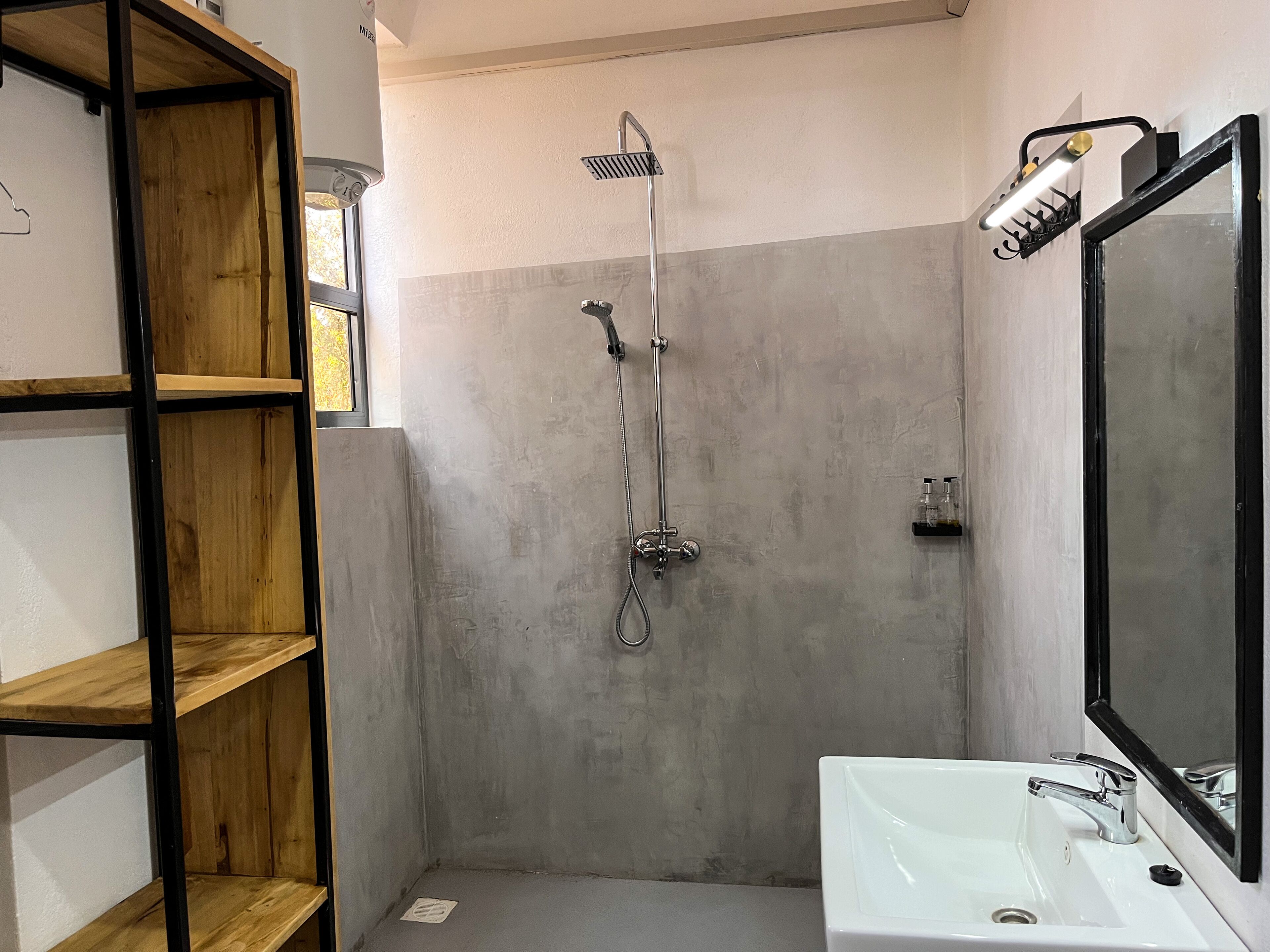 A bathroom with a shower, a sink, and a mirror.