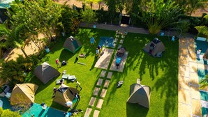 Luchtbeeld van een camping met tenten, een zwembad en een verhard pad.