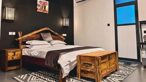 Een moderne slaapkamer met een houten bed, nachtkastje, dressoir, een kamerkleed met dessin en een groot raam met uitzicht.