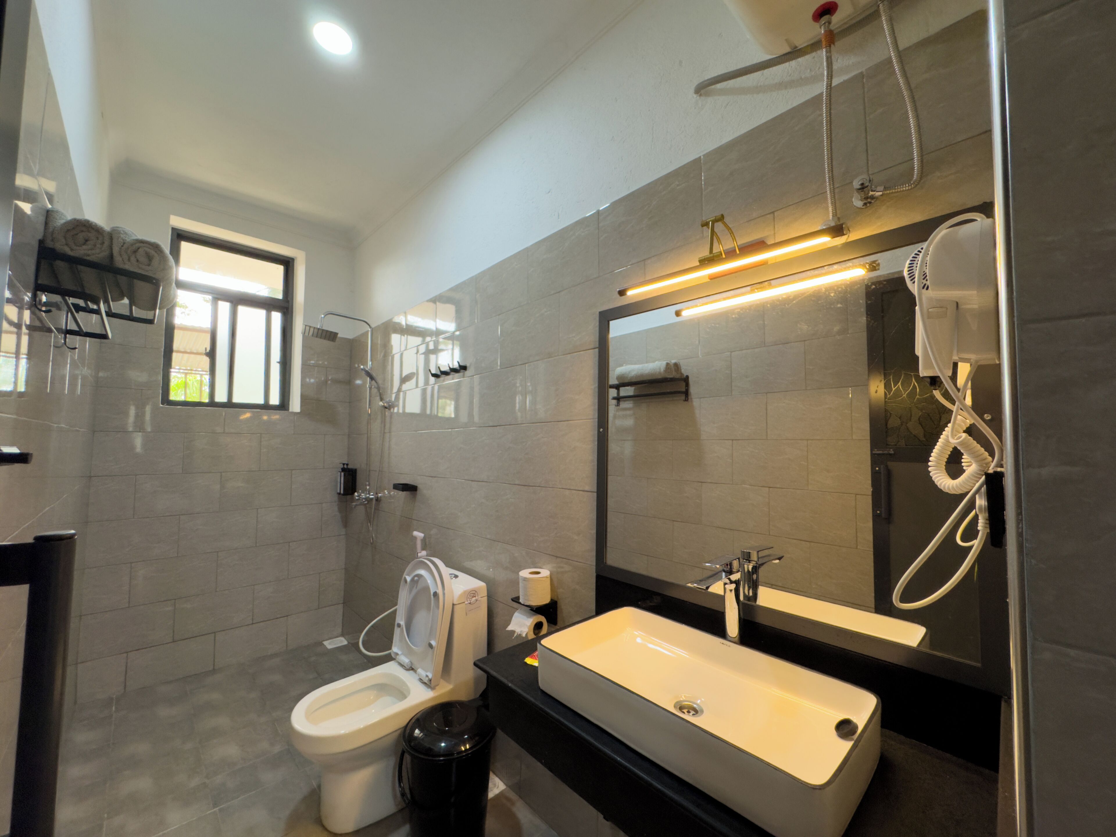 A modern bathroom with a toilet, sink, and shower.