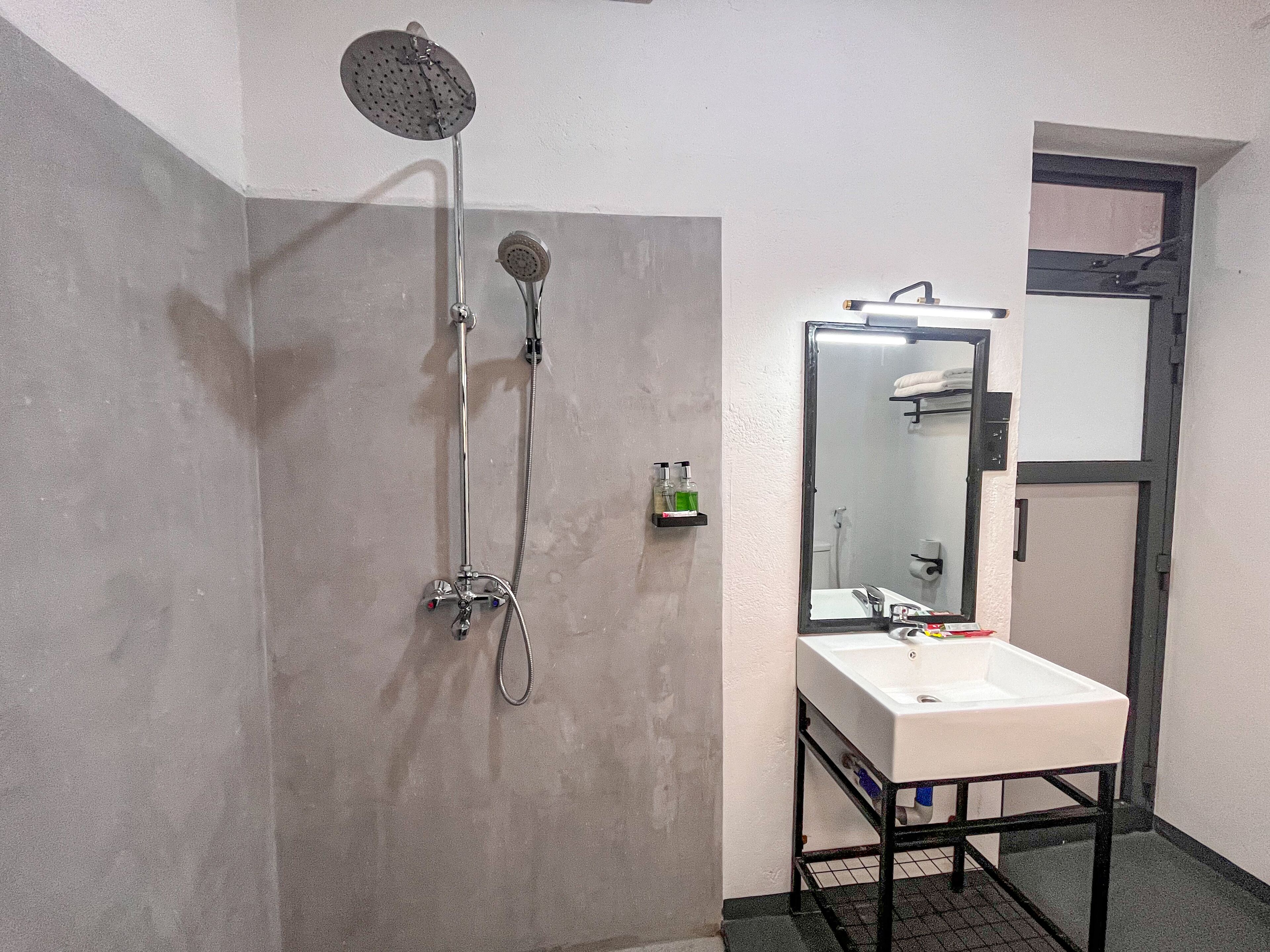 Un baño con ducha, lavabo y espejo.