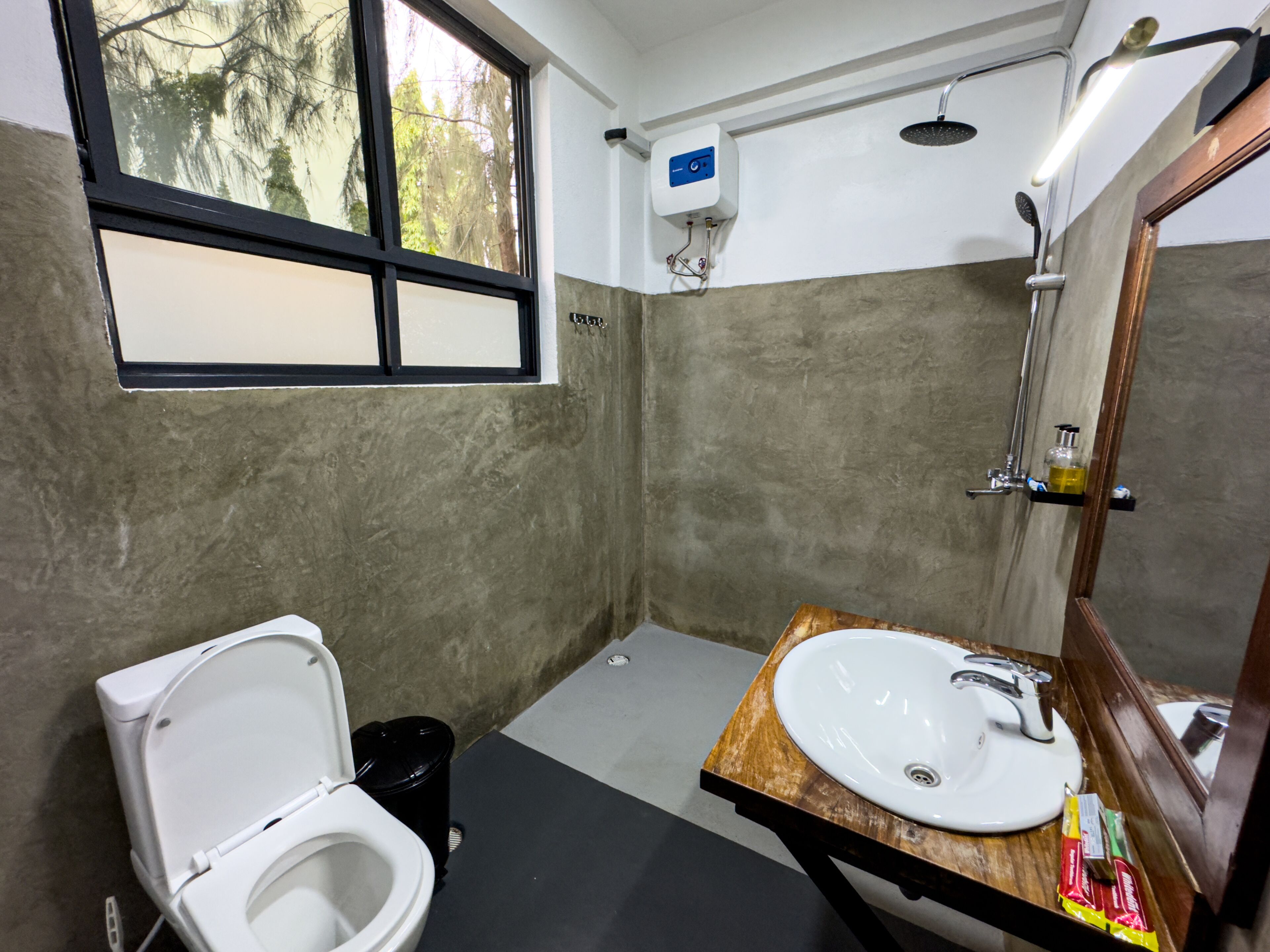 A bathroom with a toilet, sink, and shower.
