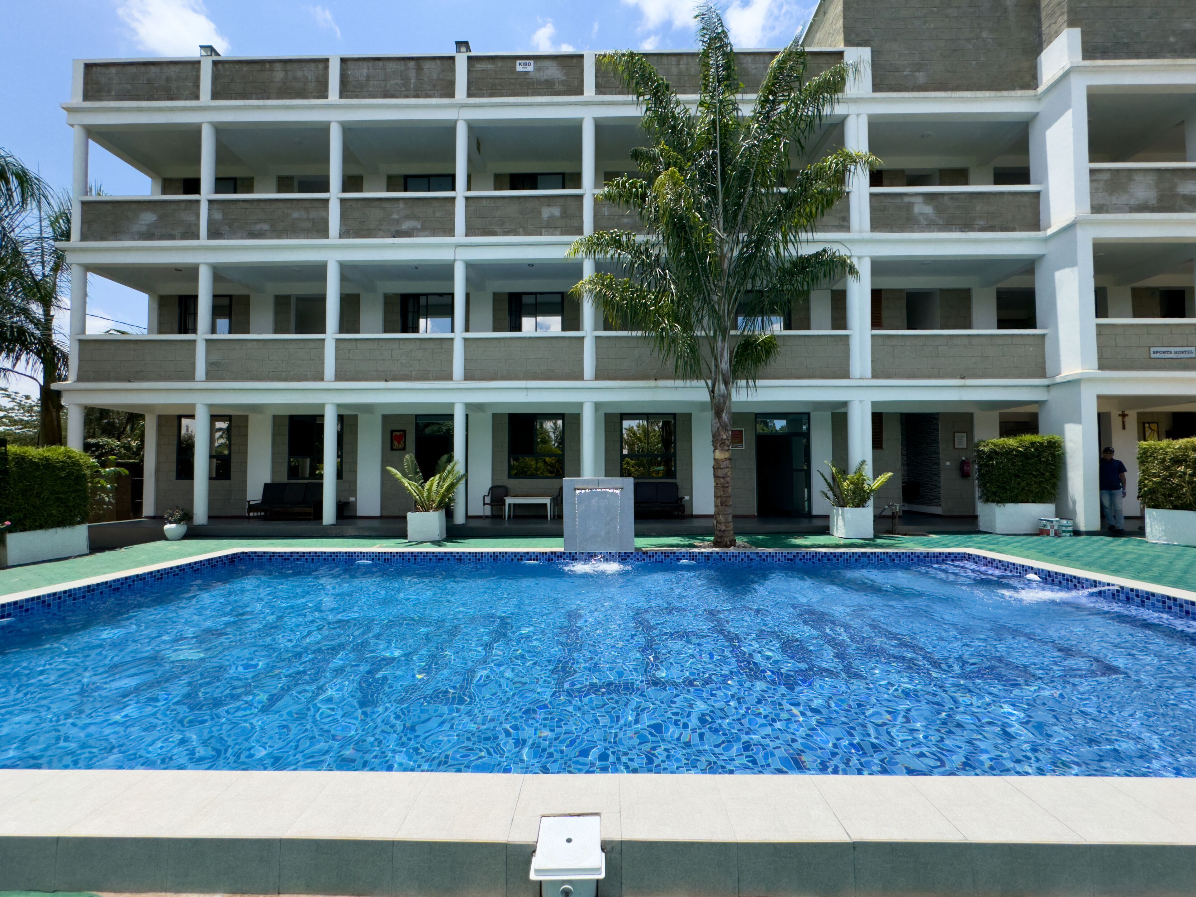 A multi-story hotel with a swimming pool in the foreground.