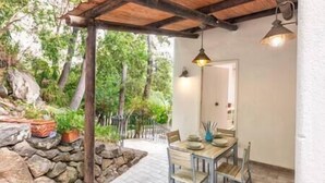 A covered patio with a table and chairs, surrounded by a stone wall and greenery. - Charming Villa, Ischia, Punta Caruso, Forio, n.4 (forio)