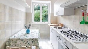 A compact kitchen with white cabinets, a gas stove, and a window providing a view of greenery outside. - Charming Villa, Ischia, Punta Caruso, Forio, n.4 (forio)