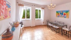 A spacious room with a dining table and chairs, large windows with curtains, and artwork on the walls. - Charming Villa, Ischia, Punta Caruso, Forio, n.4 (forio)