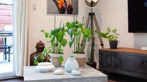 A living room with a marble table, potted plants, a painting, a lamp, and a television. - Villa 'Baraka' with Private Pool, Wi-Fi and Air Conditioning (SALON DE PROVENCE)