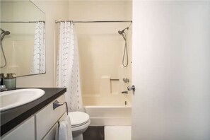 Enjoy a refreshing shower in this bathroom featuring a bathtub, sink, and toilet.