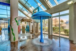 A spacious indoor area with a water feature in the center, large windows, and a wet floor.