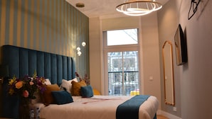 A modern bedroom with a tufted headboard, a large window, and a view of the outside. - If boutique hotel (Amsterdam)